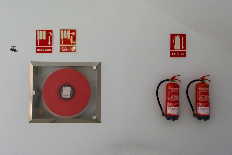Fire extinguishers and a hose reel on a wall